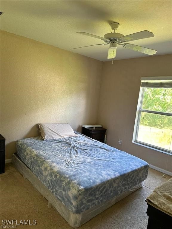 bedroom featuring ceiling fan and light carpet