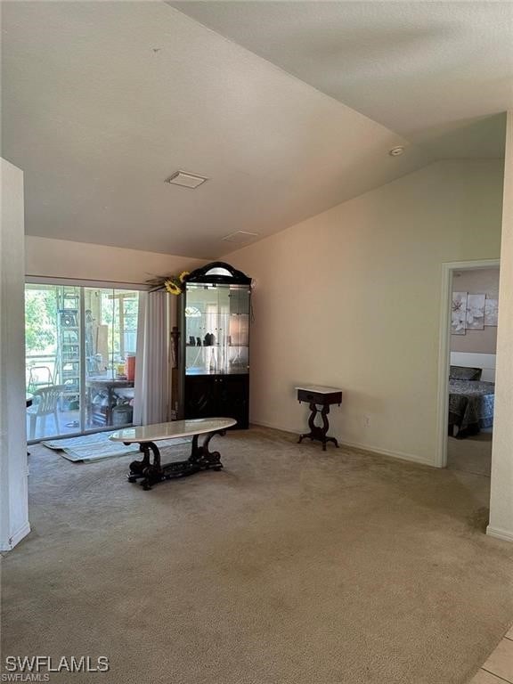 unfurnished living room with light carpet and lofted ceiling