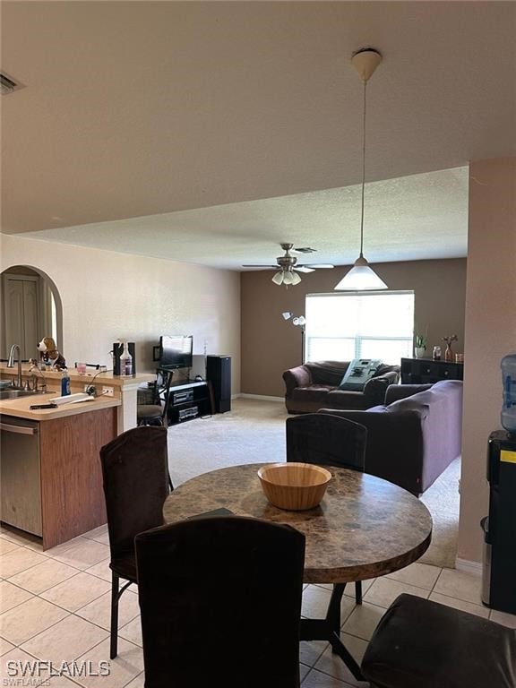 tiled dining room featuring ceiling fan and sink