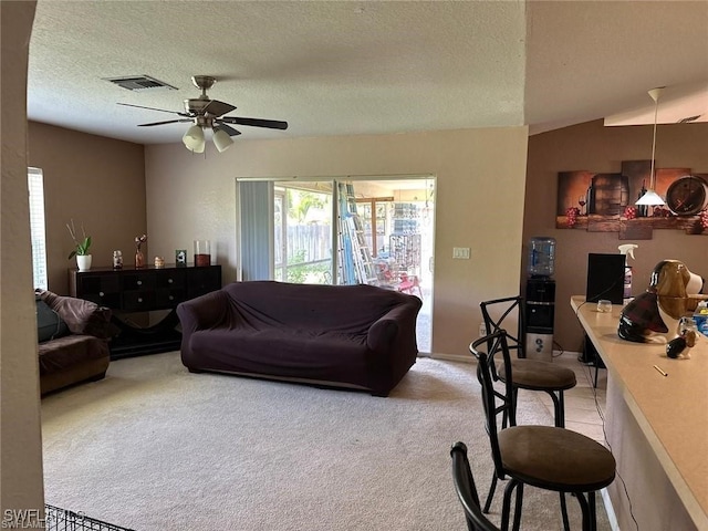 living room featuring a textured ceiling, light colored carpet, ceiling fan, and lofted ceiling