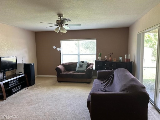 living room featuring light carpet, a textured ceiling, a wealth of natural light, and ceiling fan