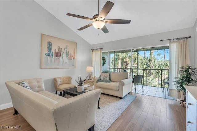 living room featuring vaulted ceiling, ceiling fan, and light hardwood / wood-style flooring