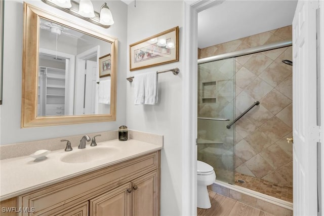 bathroom with vanity, a shower with door, and toilet