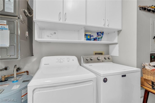 washroom with electric panel, cabinets, and washing machine and clothes dryer