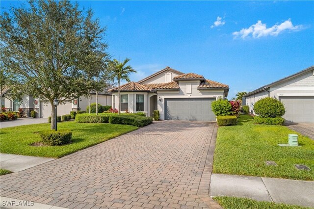 mediterranean / spanish-style house featuring a front yard and a garage