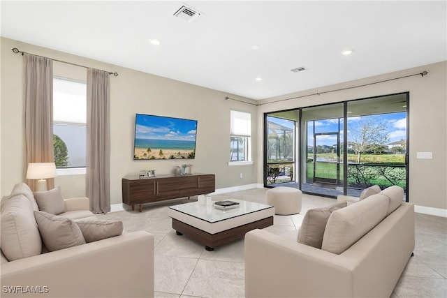 living area with baseboards, visible vents, and recessed lighting