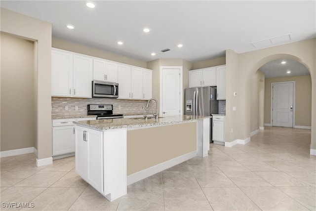 kitchen with a center island with sink, white cabinets, and stainless steel appliances