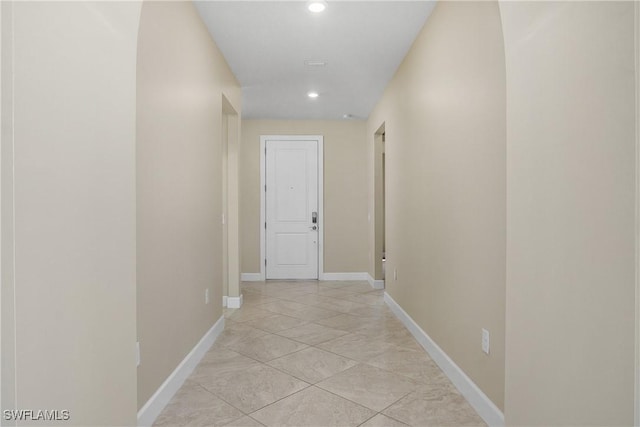 hall with baseboards and recessed lighting