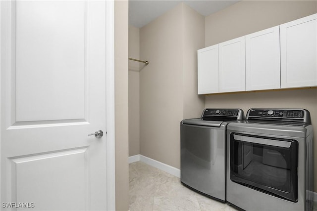 washroom with light tile patterned flooring, cabinets, and separate washer and dryer