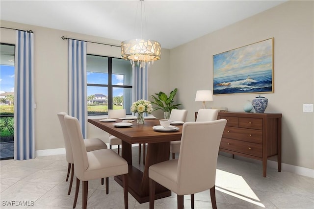 dining room with a healthy amount of sunlight, baseboards, and an inviting chandelier