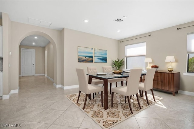 dining room with baseboards, visible vents, arched walkways, and recessed lighting