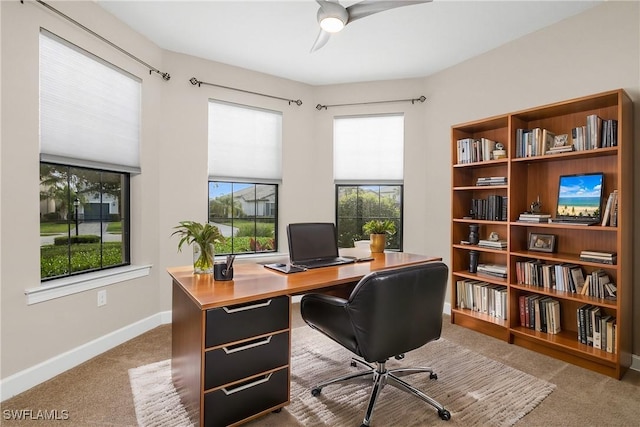 carpeted office space with ceiling fan