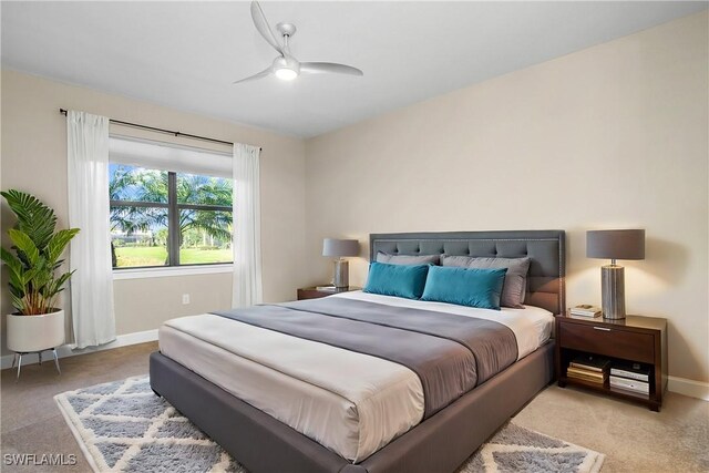 bedroom with light carpet, ceiling fan, and baseboards