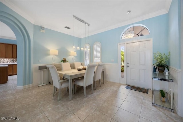 tiled dining space featuring crown molding