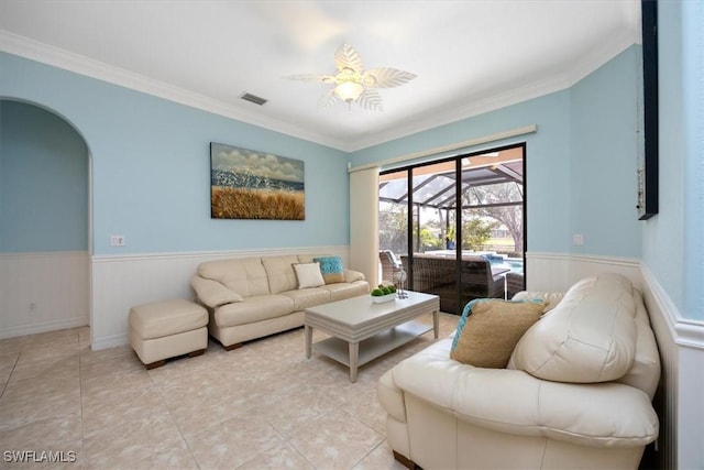 living room with light tile patterned floors, ornamental molding, and ceiling fan