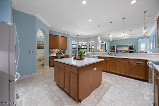 kitchen featuring pendant lighting, white appliances, a healthy amount of sunlight, and a kitchen island