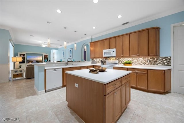 kitchen with sink, white appliances, hanging light fixtures, a center island, and kitchen peninsula