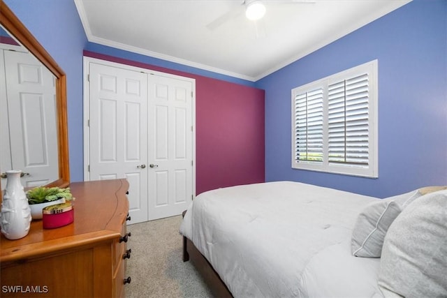 carpeted bedroom featuring ornamental molding, a closet, and ceiling fan