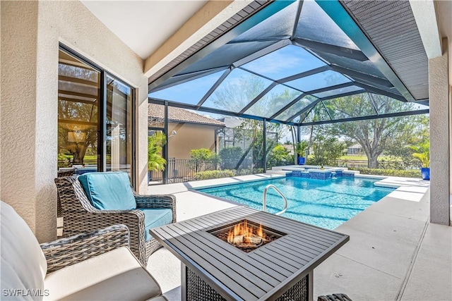 view of pool featuring a patio, glass enclosure, and an outdoor fire pit