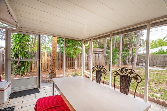 sunroom / solarium featuring rail lighting