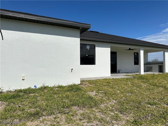 back of house featuring ceiling fan, a yard, and a patio