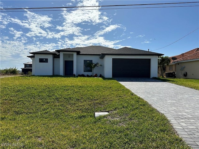 view of front of home with cooling unit, a front yard, and a garage