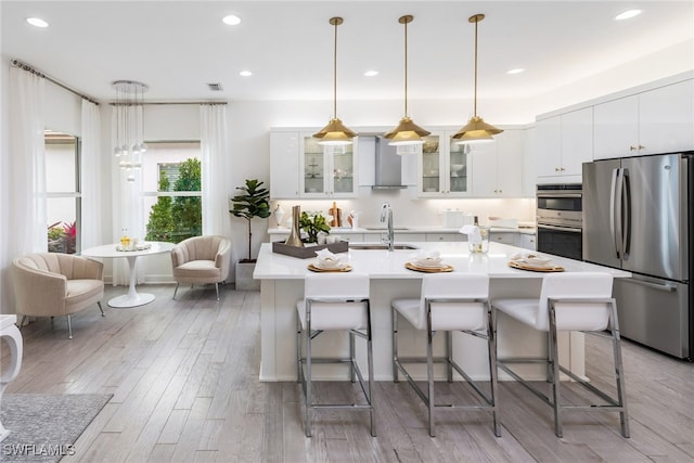 kitchen featuring sink, a breakfast bar, pendant lighting, and appliances with stainless steel finishes