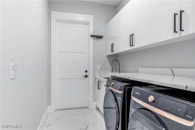 washroom with washing machine and dryer, sink, and cabinets