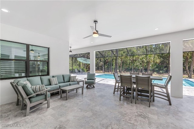 view of patio / terrace featuring glass enclosure, ceiling fan, and an outdoor living space