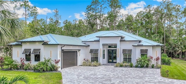 view of front of property with a garage, a front yard, and french doors