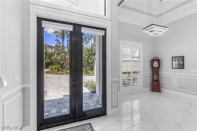 doorway with ornamental molding and french doors