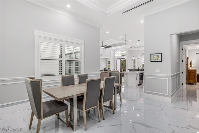 dining area with ceiling fan, sink, and ornamental molding