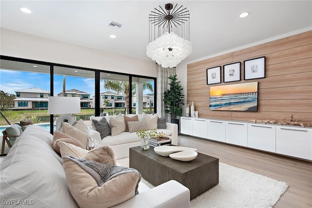 living room with light hardwood / wood-style floors and wood walls