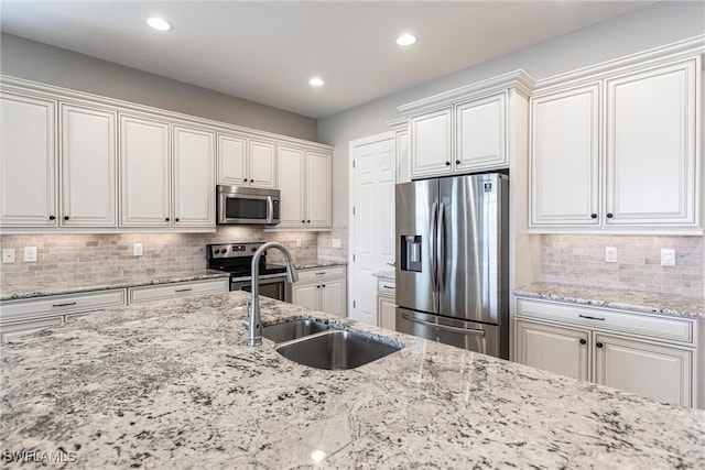 kitchen with backsplash, appliances with stainless steel finishes, sink, and white cabinets