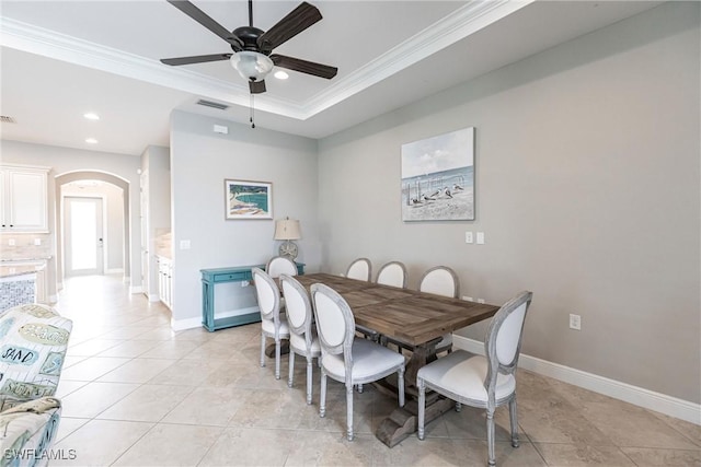 dining area with light tile patterned floors, a raised ceiling, ceiling fan, and ornamental molding