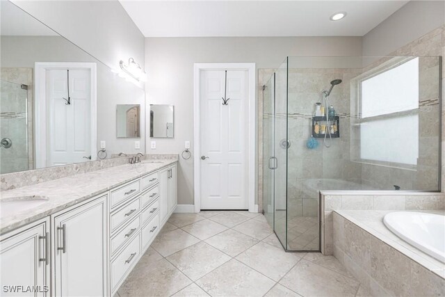 bathroom featuring shower with separate bathtub, vanity, and tile patterned floors