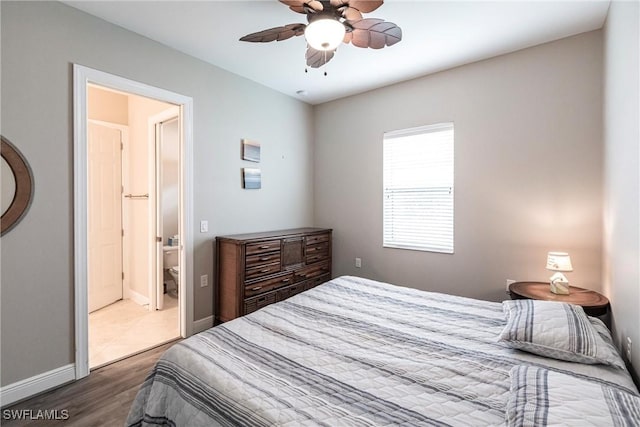 bedroom featuring connected bathroom, dark hardwood / wood-style floors, and ceiling fan