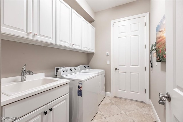 washroom with sink, cabinets, washing machine and clothes dryer, and light tile patterned flooring