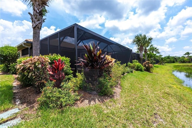 view of yard featuring a lanai and a water view