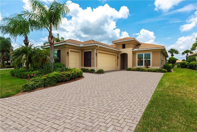 mediterranean / spanish-style house featuring a garage and a front yard