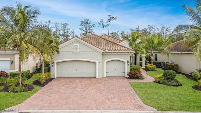 mediterranean / spanish-style home featuring a front yard and a garage