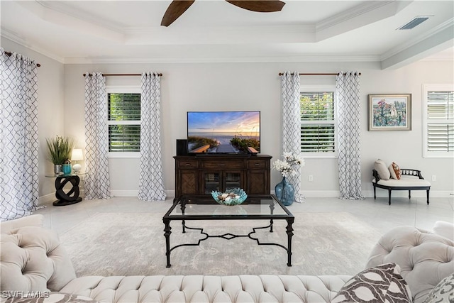 living room with ceiling fan, ornamental molding, and a raised ceiling