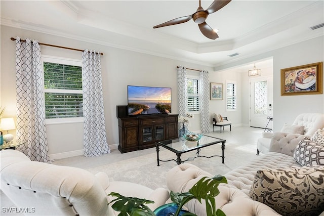 living room with a raised ceiling, ceiling fan, light carpet, and crown molding