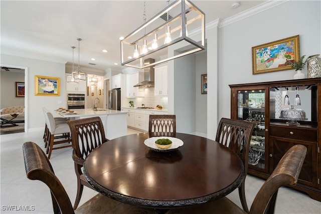 dining room featuring sink and crown molding