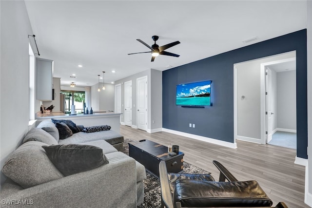 living room with ceiling fan and light hardwood / wood-style floors