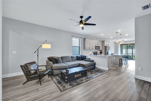 living area featuring visible vents, ceiling fan, baseboards, recessed lighting, and wood finished floors