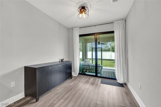 unfurnished room with visible vents, light wood-style flooring, and baseboards