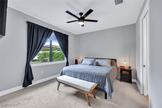 bedroom with a ceiling fan, light colored carpet, visible vents, and baseboards