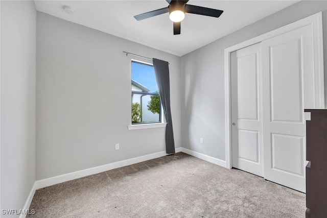 unfurnished bedroom with a closet, baseboards, ceiling fan, and carpet flooring