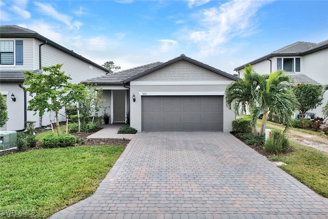 view of front of house with decorative driveway, a front lawn, an attached garage, and stucco siding